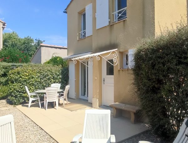 Jardin privatif avec terrasse, table extérieure et espace convivial pour l'apéritif.